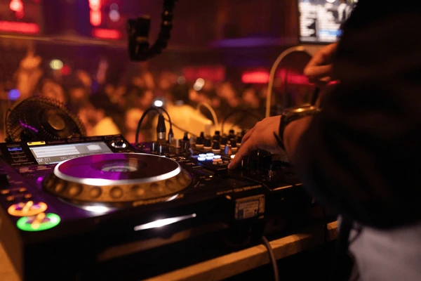Close-up platines : main de DJ Nova sur le fader